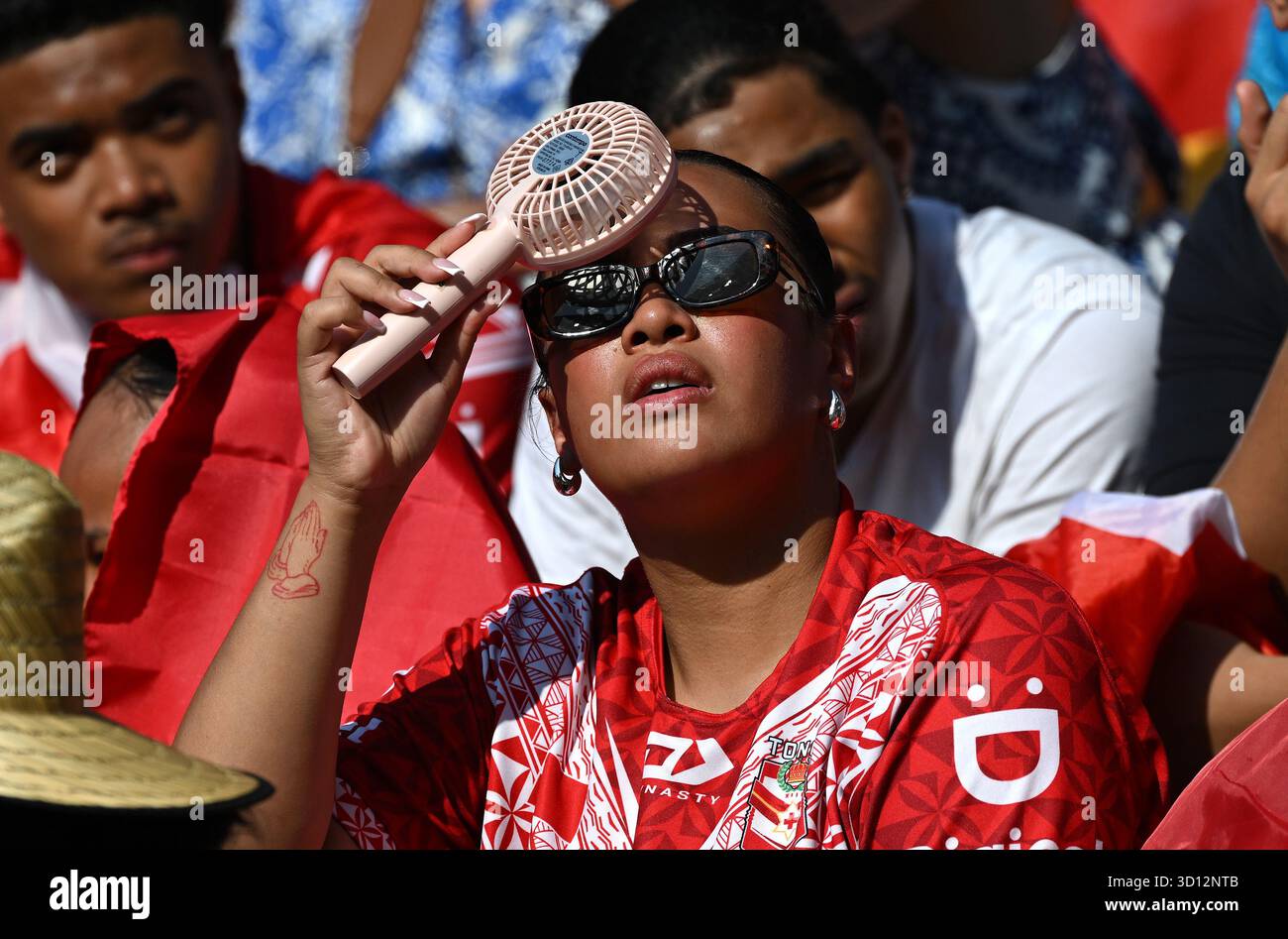 A spectator cools with a fan during the rugby league Pacific Cup Men’s ...