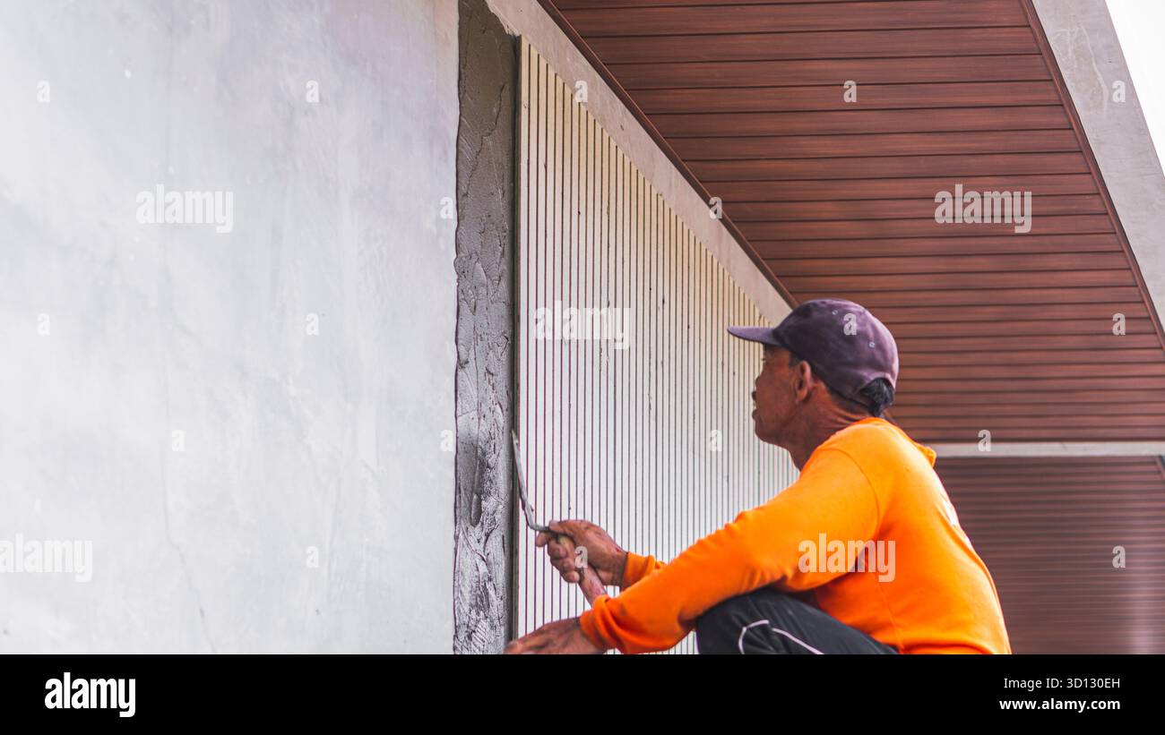 Worker applying Conwood adhesive on the wall, an essential step in
