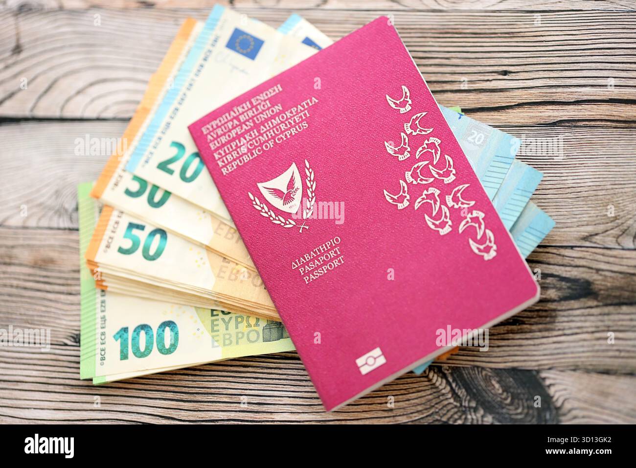 Kyprus passport lies with euro money banknotes on wooden background close up. Cash and payments in Europe concept Stock Photo