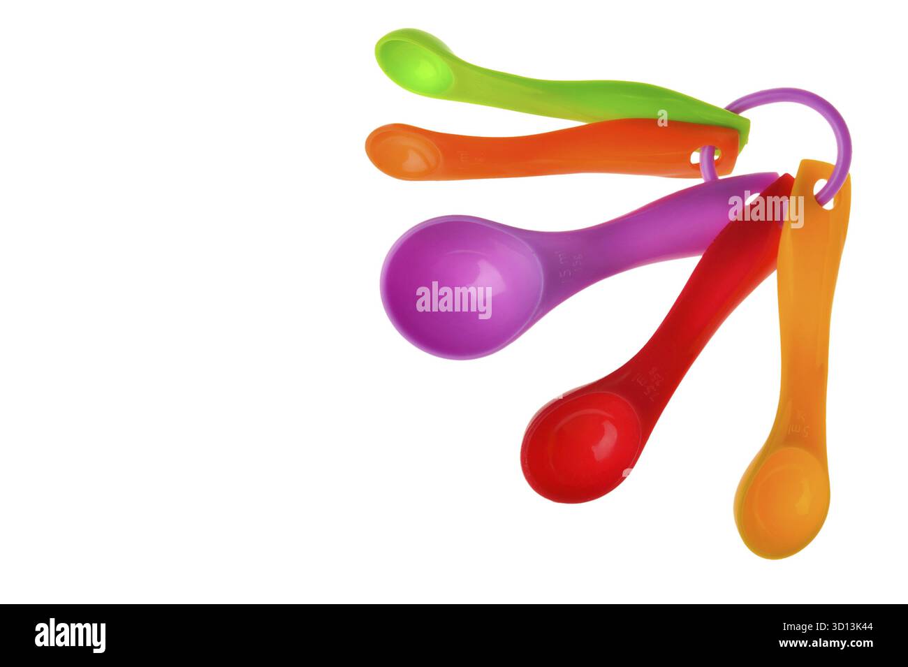 Multicolored plastic measuring spoons in grams isolated on white Stock Photo