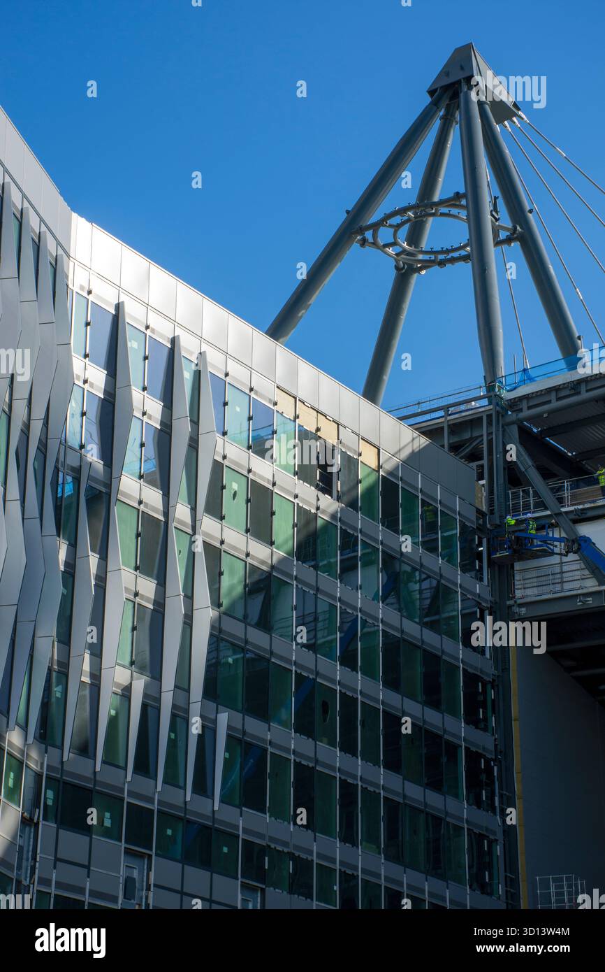 The hotel section of the Etihad North Stand expansion scheme and a support tower for the roof support cables, Etihad campus, Manchester, England, UK. Stock Photo