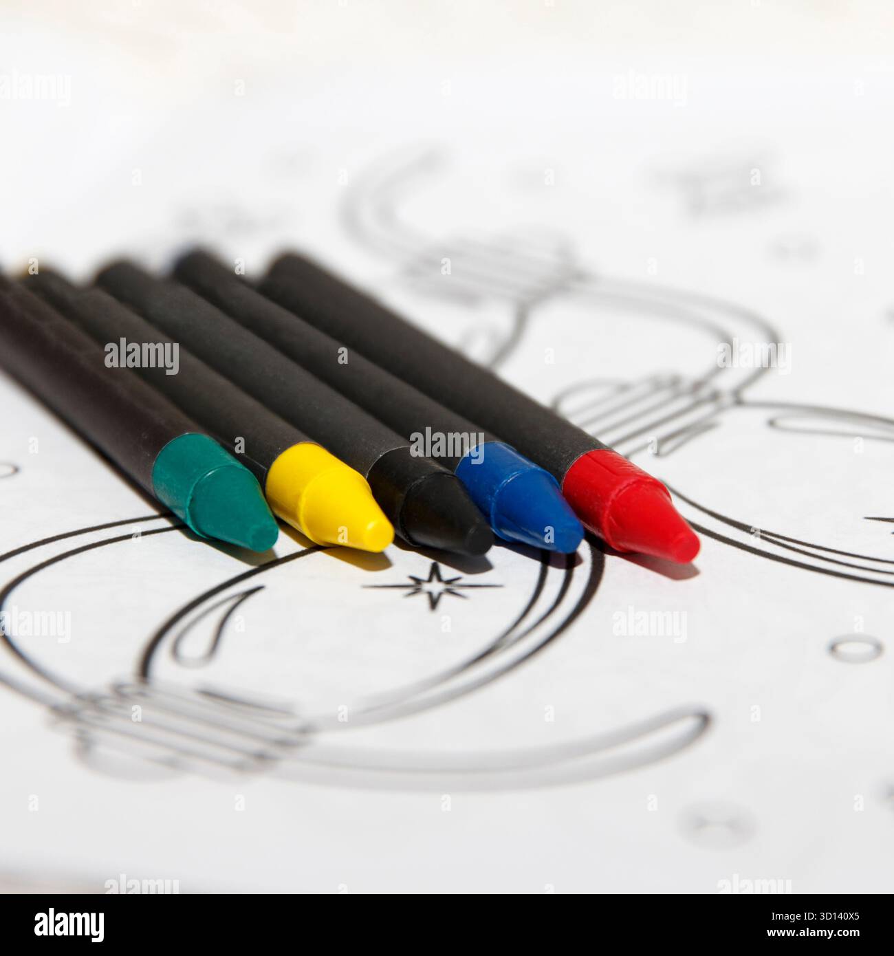 Feature Simple Image Coloring markers arranged on a table next to coloring pages. Markers ...
