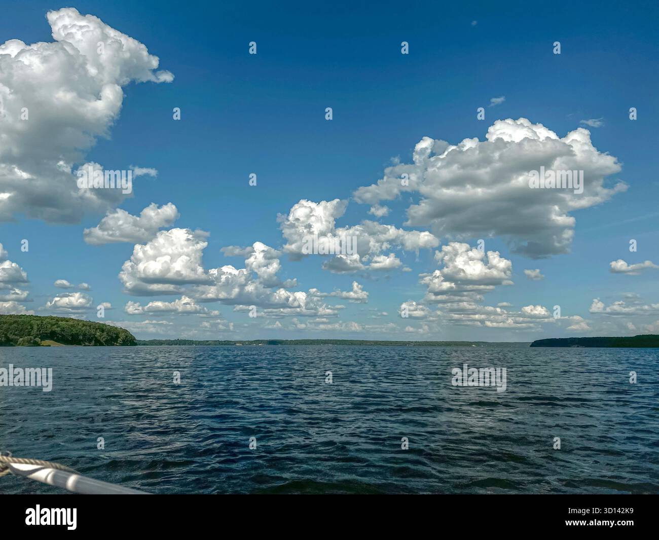 Sailing on Kaunas Marios,Lithuania. View from a yacht sailing on Kaunas Marios on a sunny summer day,with blue water and cloud-filled sky. - Smartphone Captured Stock Image