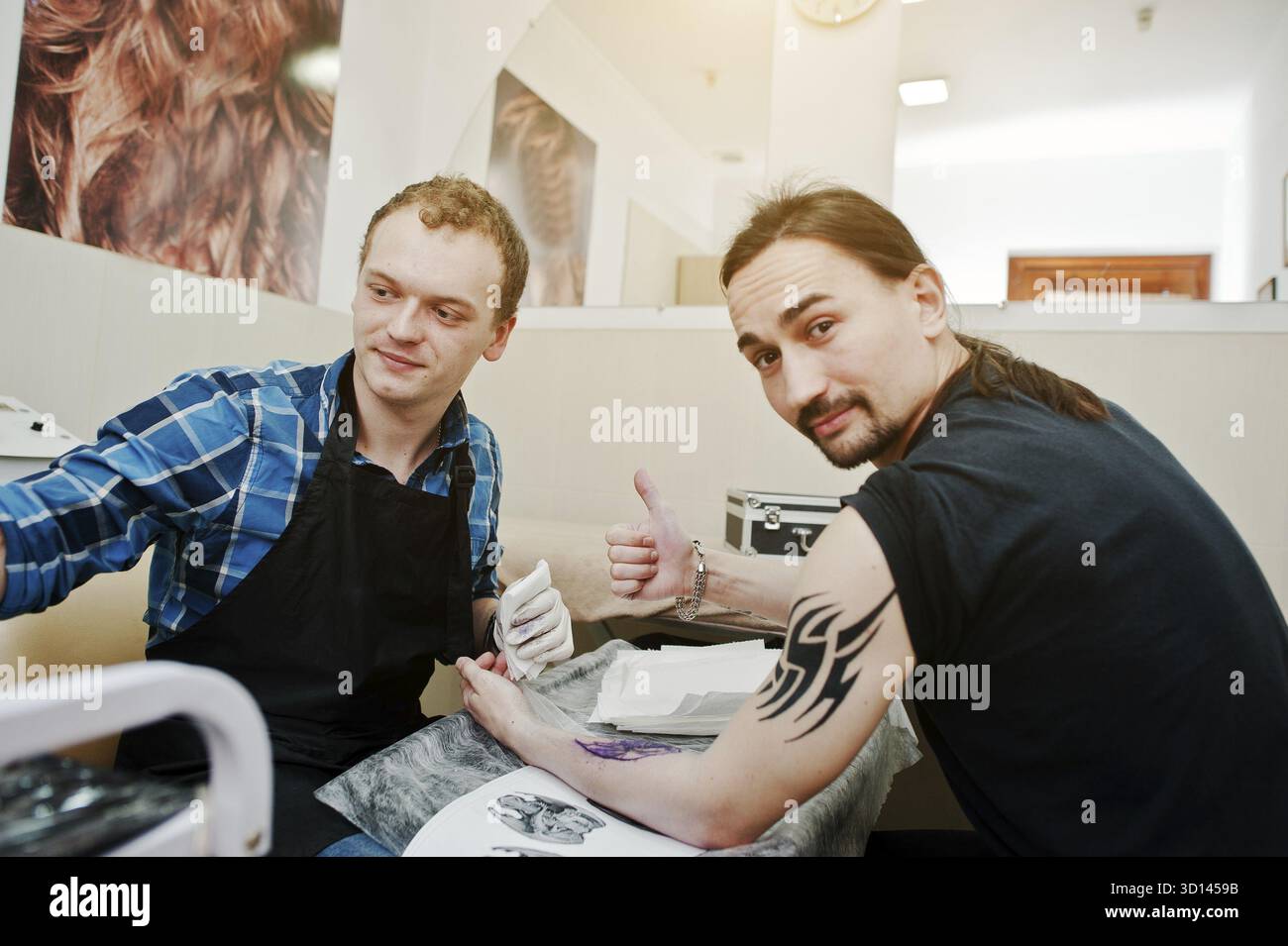 Tattoo master make tattoo for rocker man at tattoo salon Stock Photo ...