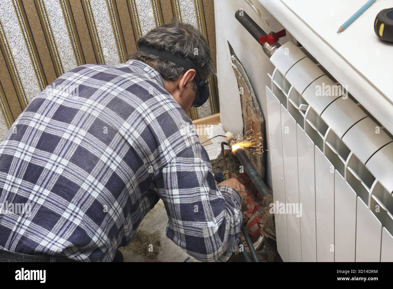 Installing new radiators with gas welding Stock Photo