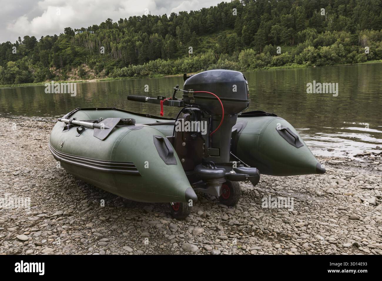 The green boat of pvc with the water-jet engine on the river bank Stock ...