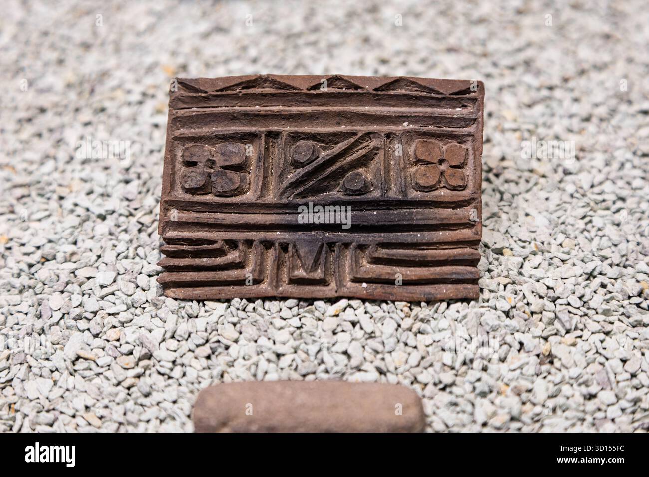 Carved clay stamp with geometric and floral motifs from Teotihuacan, used for decoration or ritual body art. Stock Photo