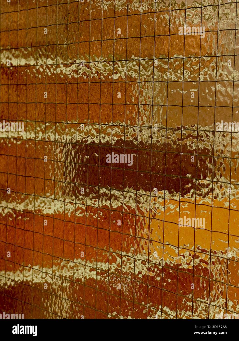 Brick wall seen behind textured glass with wire - Smartphone Captured Stock Image