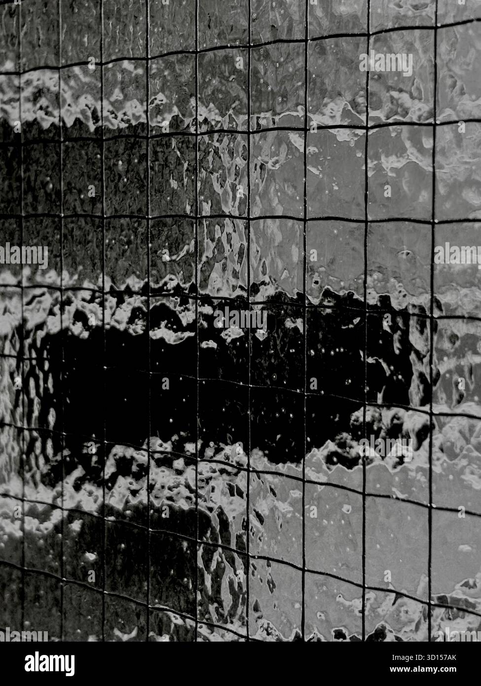 Brick wall seen behind textured glass with wire - Smartphone Captured Stock Image