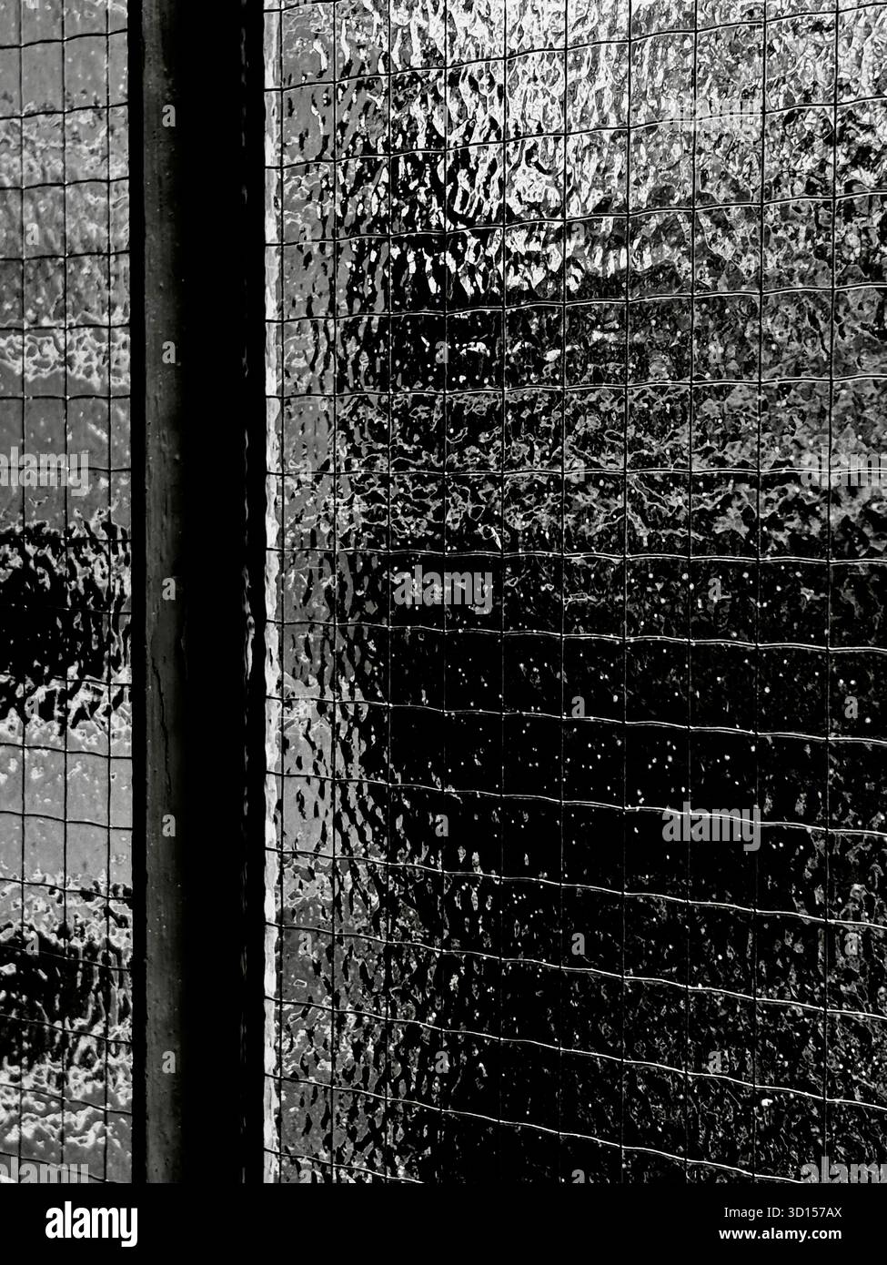 Brick wall seen behind textured glass with wire - Smartphone Captured Stock Image