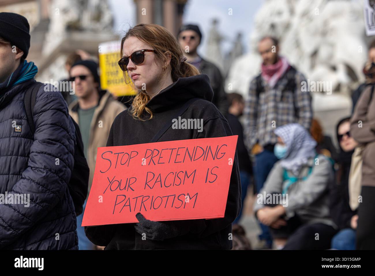 Woman holding sign stop Pretending Your Racism Is Patriotism at Stop the Hate and stop the far right demonstration in London. Stock Photo