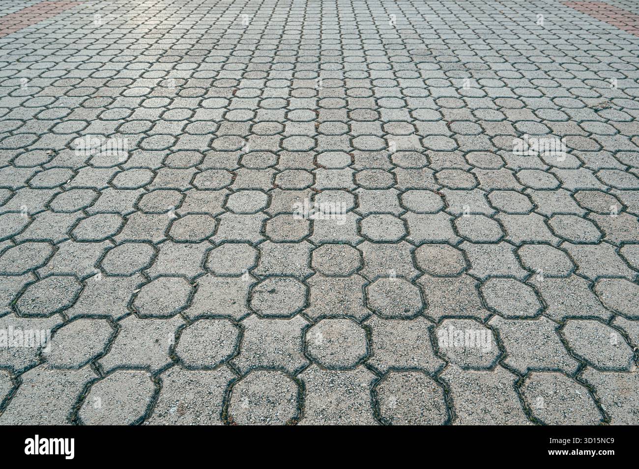 Hexagonal cement paving pattern forming geometric texture in diminishing perspective. Selective focus. Stock Photo