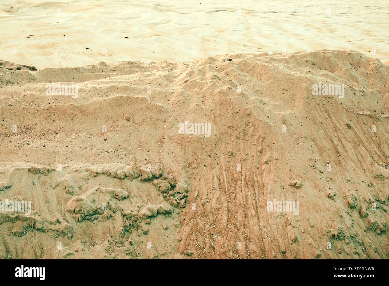 Closeup texture of dry beach sand with natural patterns and small ridges formed by wind and water erosion. Selective focus. Stock Photo