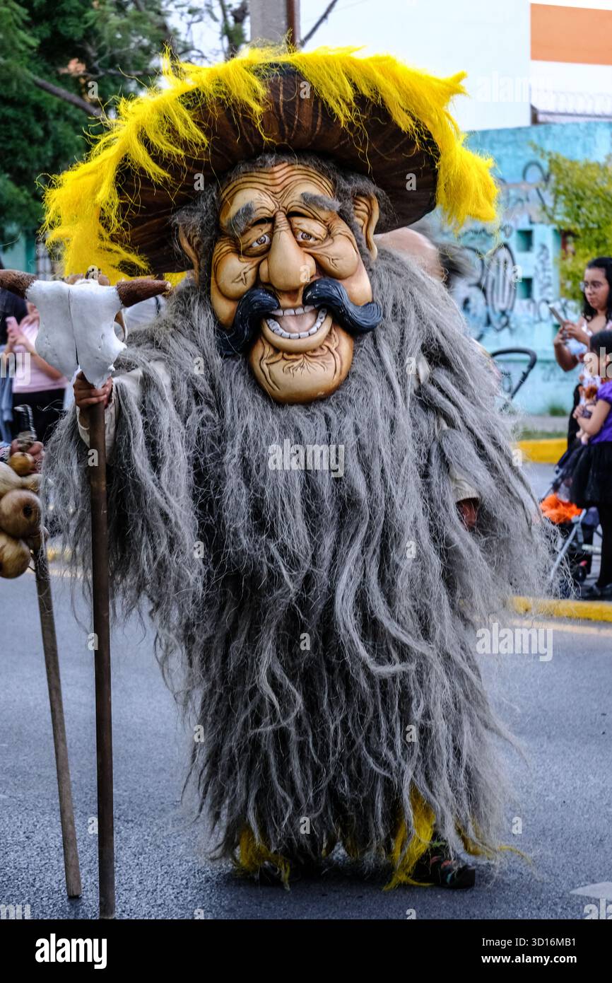 Person in elaborate "Xita" costume with long gray beard and oversized mask during a Xantolo (Day of the Dead) parade in San Luis Potosi, Mexico. Stock Photo