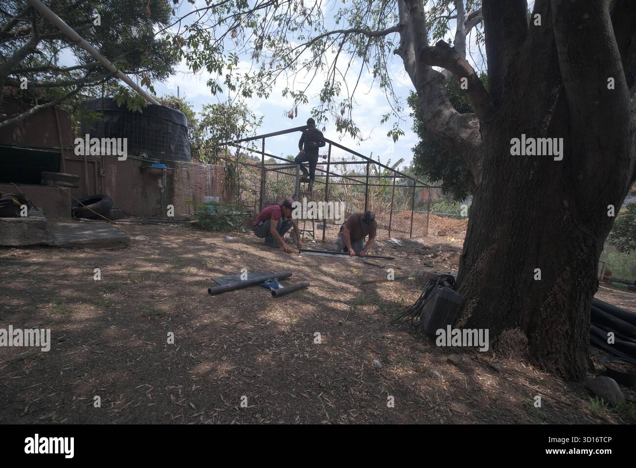 Blacksmiths working outdoors on a very simple structure Stock Photo