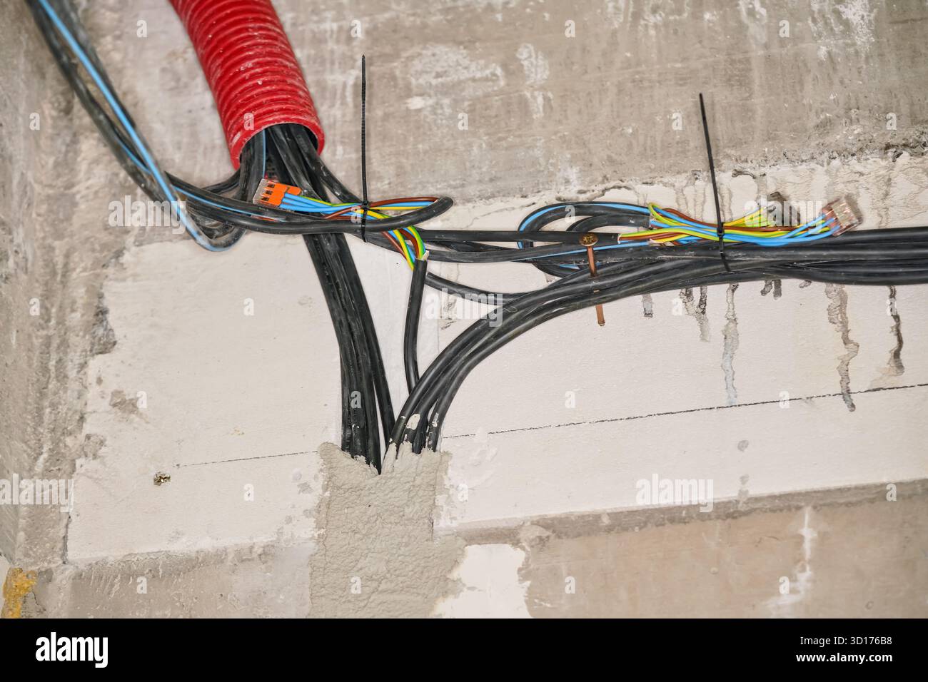 Electric power cables installation on new house construction site wall ...