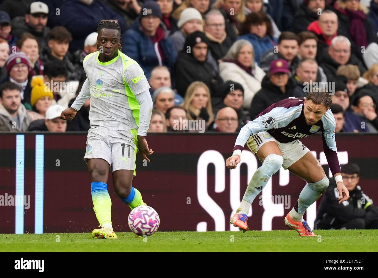 Jeremy Doku of Manchester City under pressure from Matty Cash of Aston ...