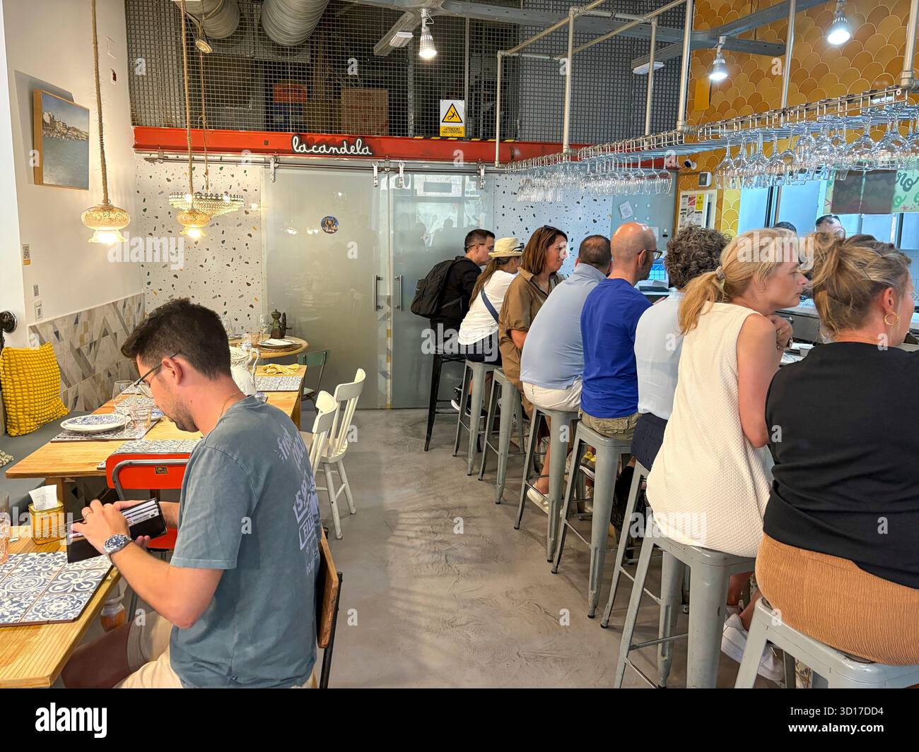 La Candela, spanish tapas restaurant in Cadiz city centre, Andalusia,Spain, customers at the kitchen counter enjoy lunch meal - Smartphone Captured Stock Image