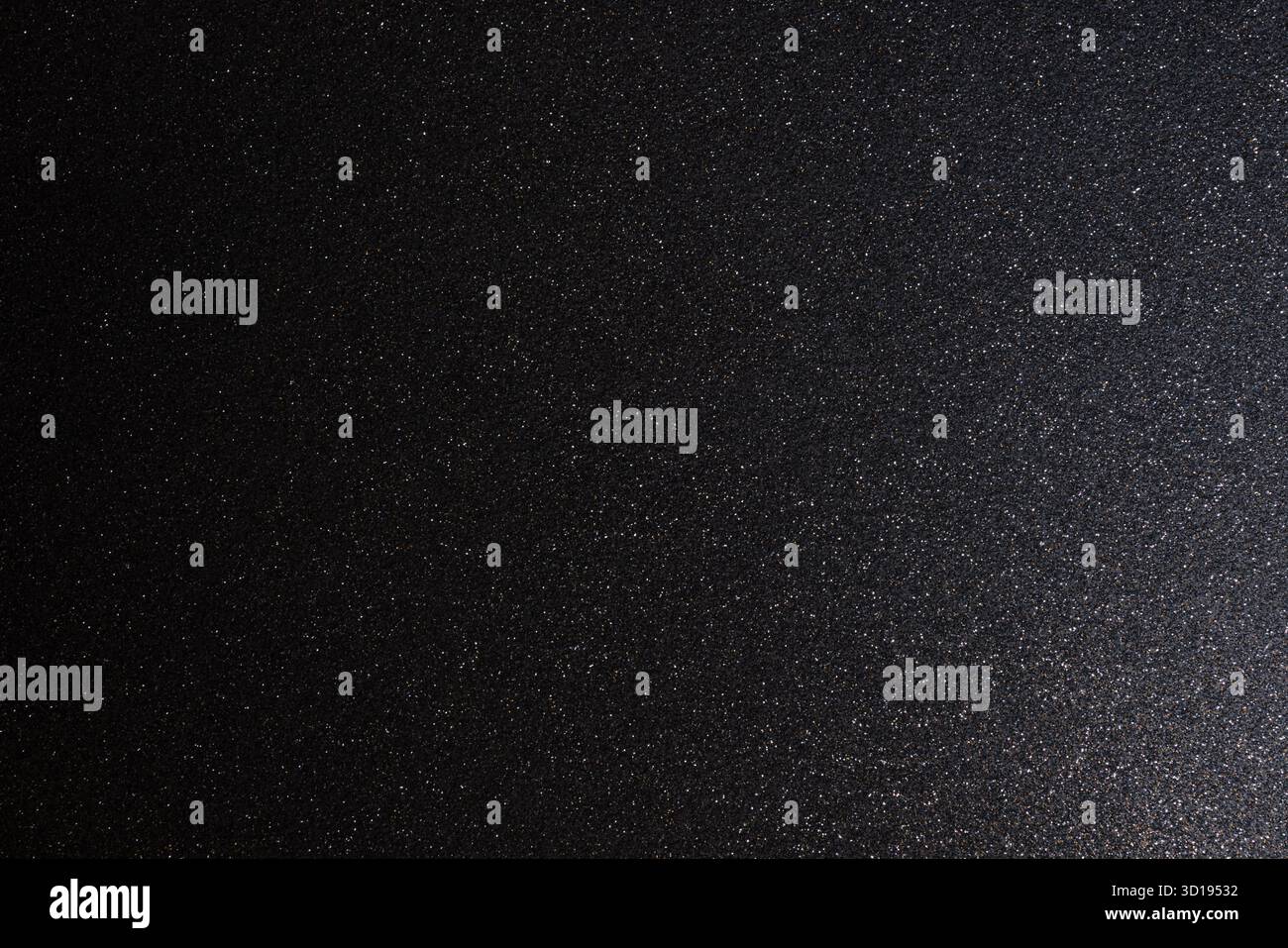 Dark metallic glitter texture illuminated softly from right, macro focus highlights subtle sparkles shimmering across abstract granular relief Stock Photo