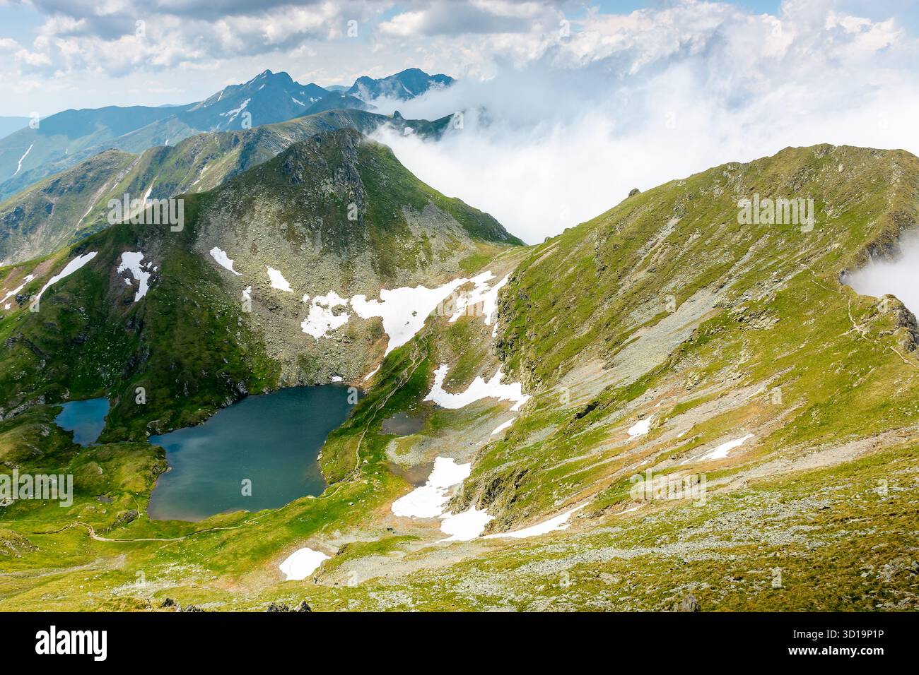 mountain landscape with alpine lake in summer. beautiful pond near popular hiking trail through transylvania alps of fagaras massif. postcard from rom Stock Photo
