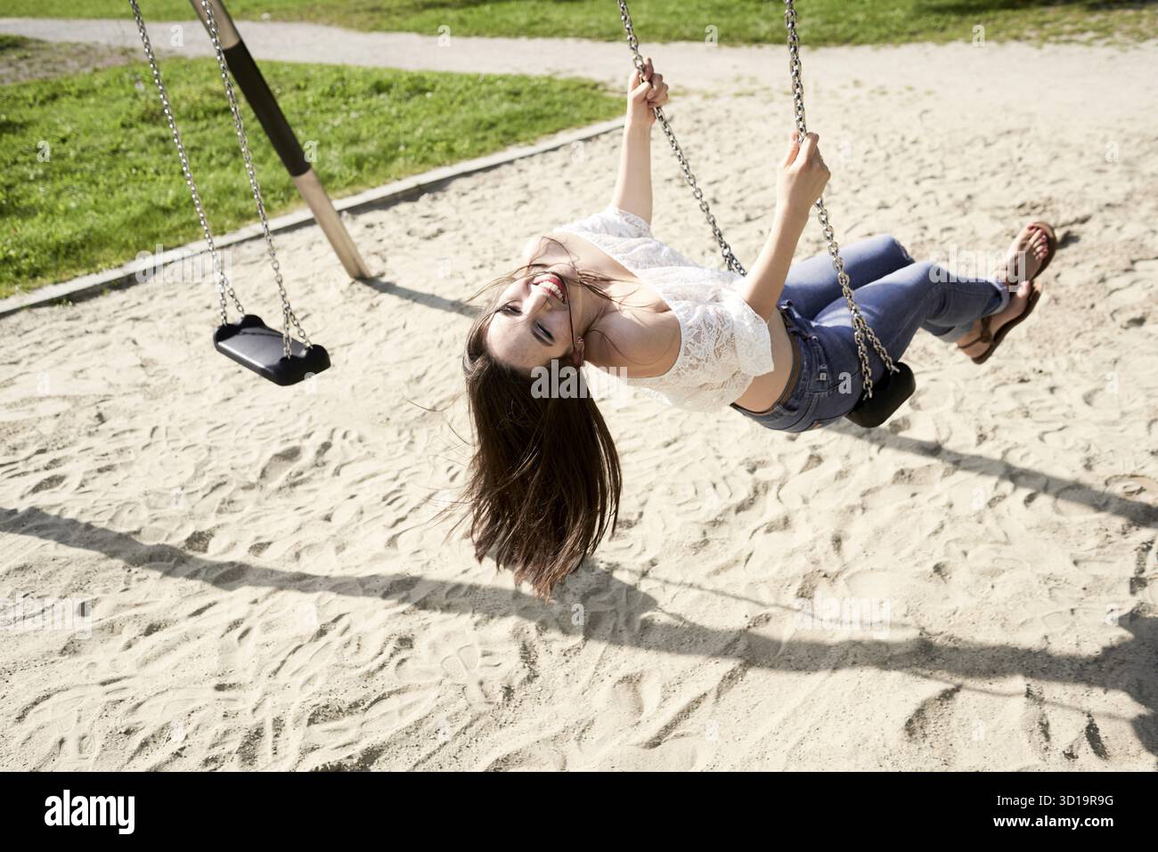 Remembering carefree childhood on swing with zestful giggles Stock Photo