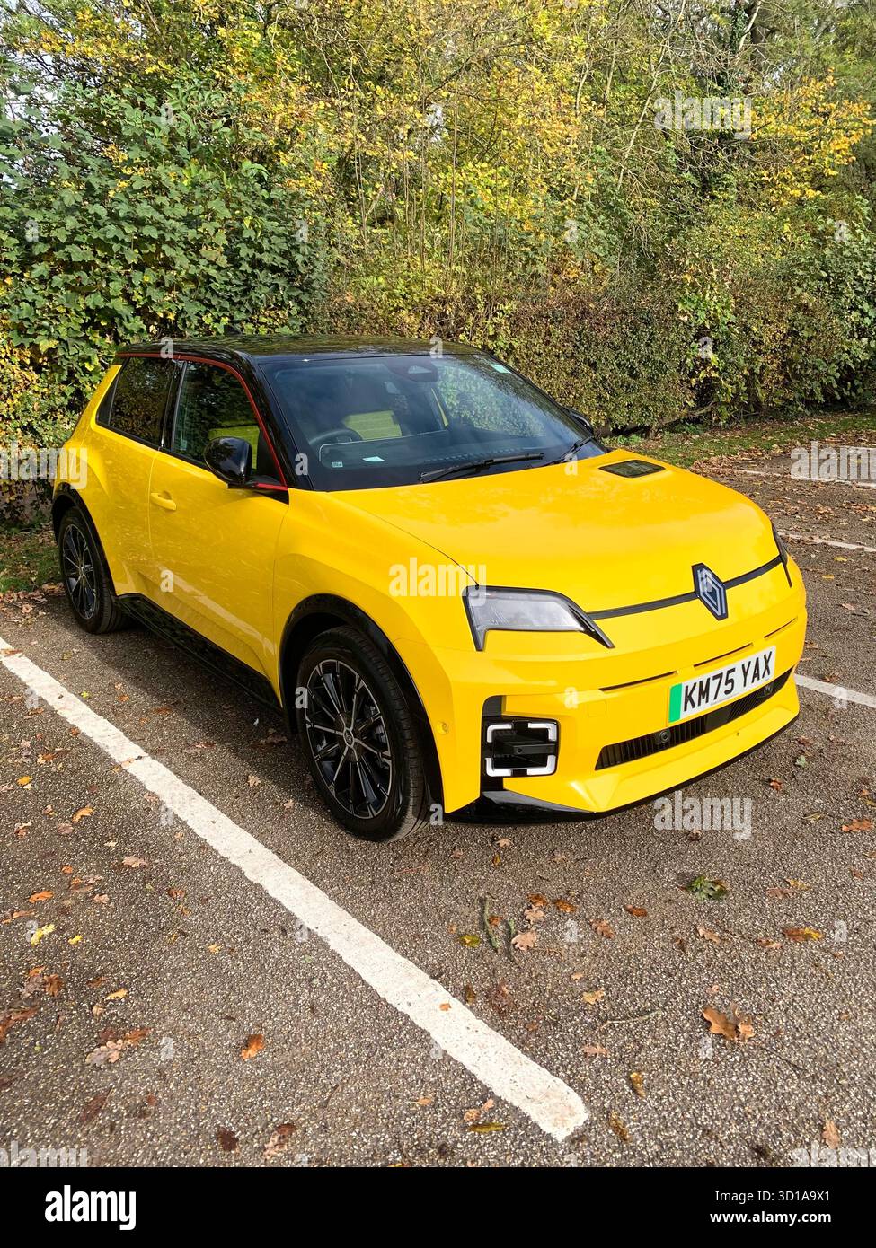 New bright Yellow Renault 5 hatchback electric car parked in a car park beside a wooded area in Summer England french car UK Britain new style - Smartphone Captured Stock Image