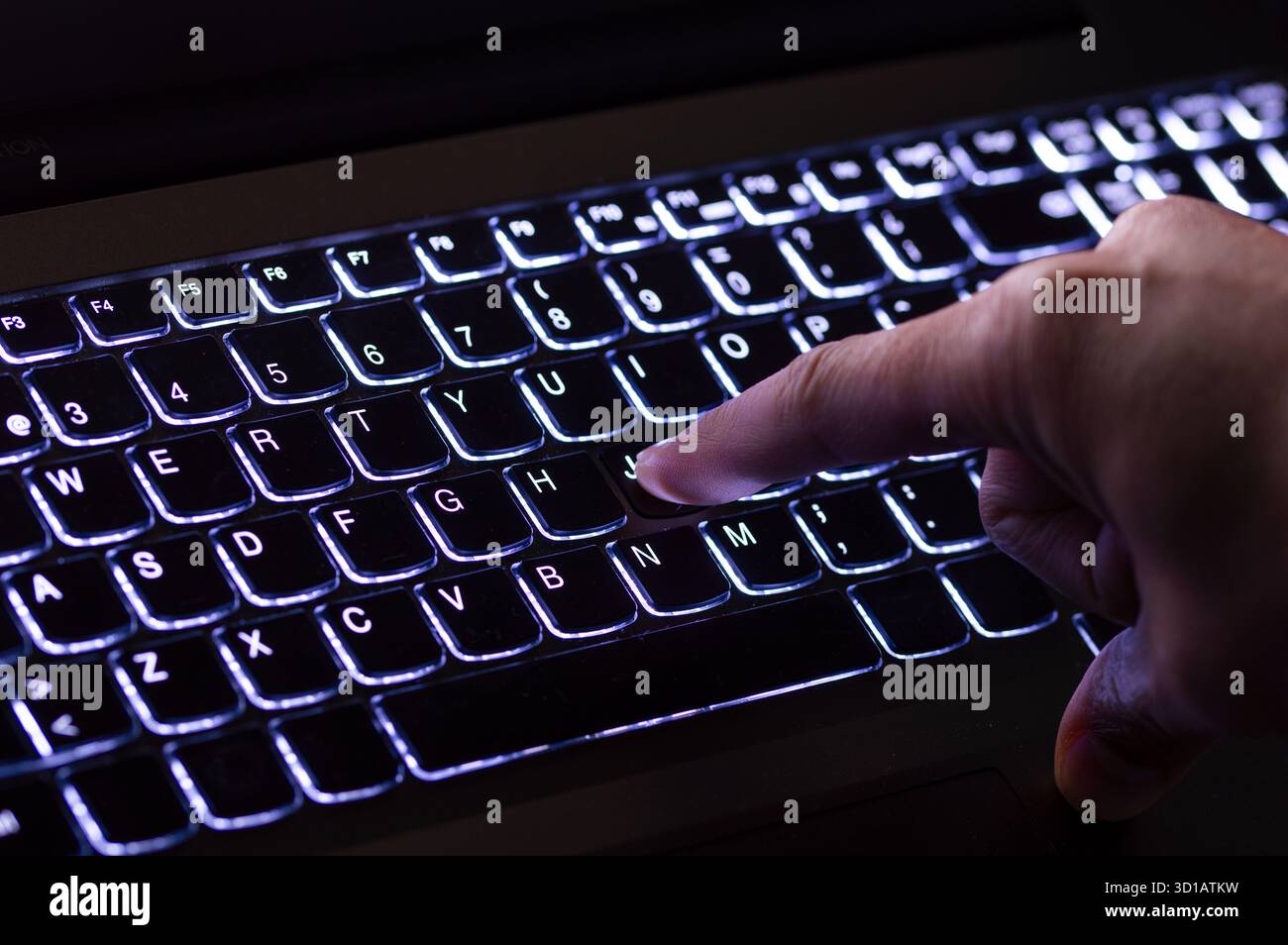 Working on a blue neon computer keyboard with colored backlighting. Computer video games, hacking, technology, internet concept. Selected focus. Stock Photo