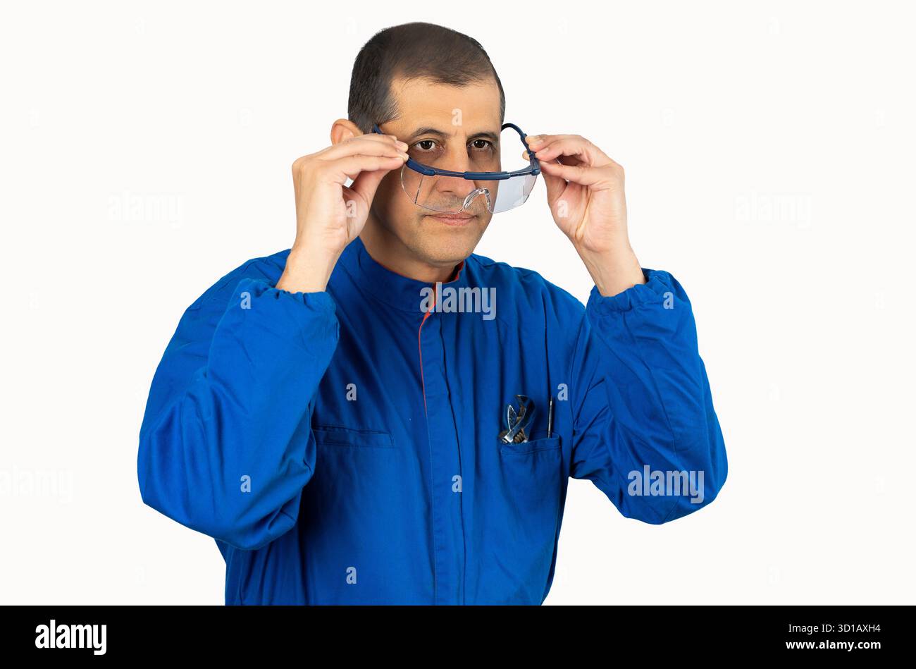 Mechanic worker putting protective glasses before work with white background. Stock Photo