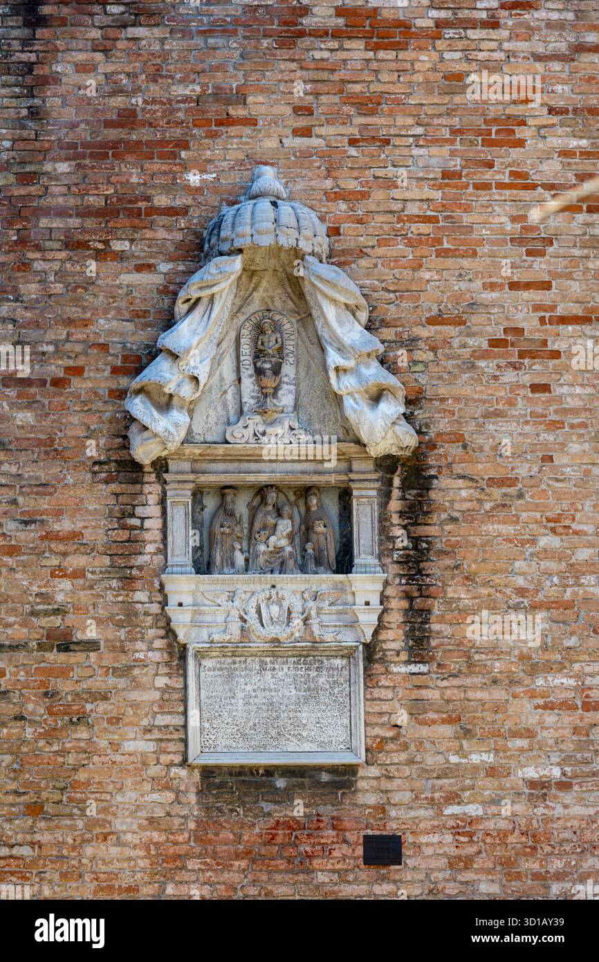 Religious stone relief sculpture on Venetian brick wall. Intricate ...