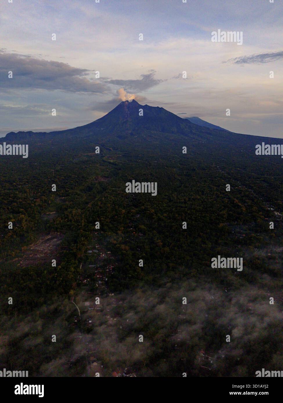 Aerial view of Mount Merapi's towering peak piercing through a sea of ...