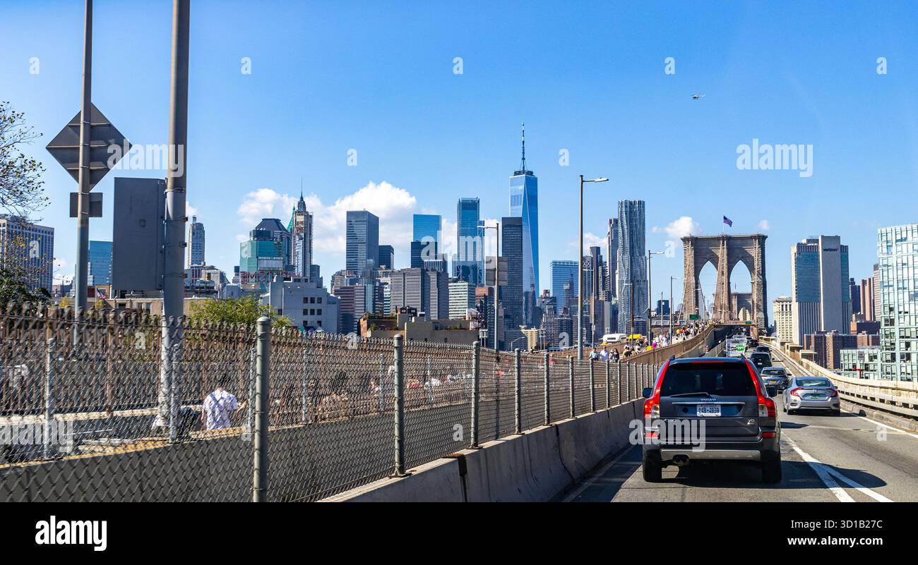 Driving over the Brooklyn Bridge into Manhattan, New York City, with downtown Manhattan and One World Trade visible beyond bridge tower, POV from car Stock Photo