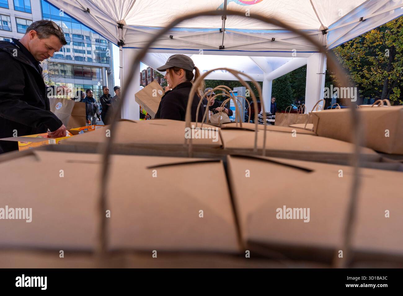 A worker, right, with chef Jose Andres' World Central Kitchen helps ...