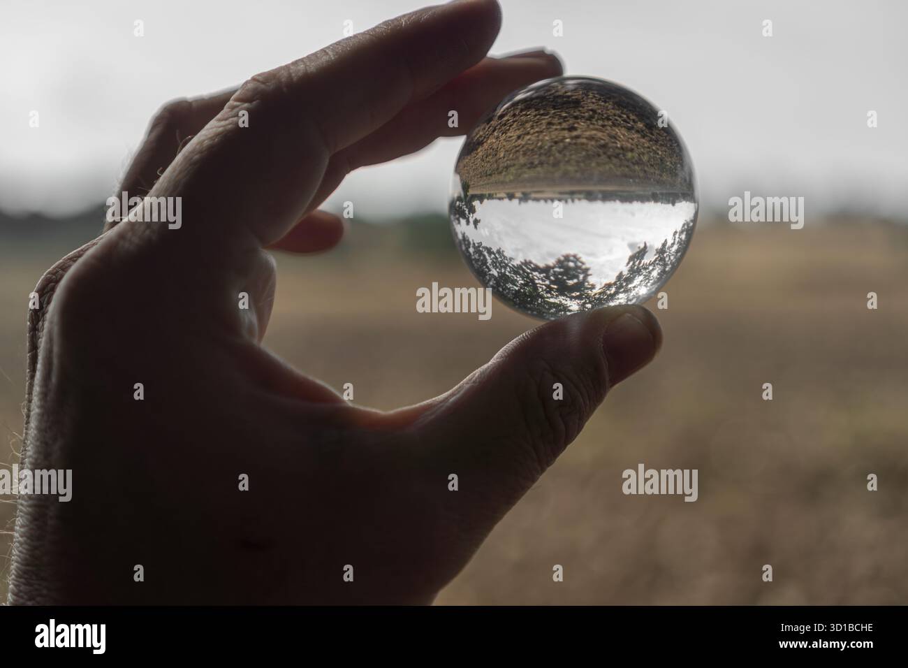Hand Holding Inverted Glass Sphere Stock Photo - Alamy