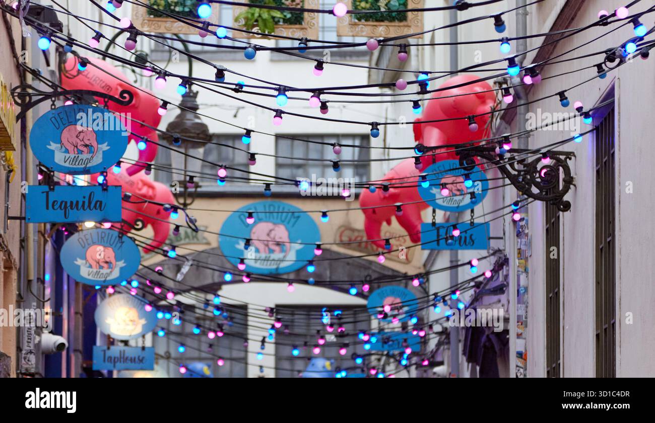 Brussels, Belgium - October 03, 2025: Illuminated Delirium beer signage hangs above lively street in Brussels, adorned with colorful lights and festiv Stock Photo