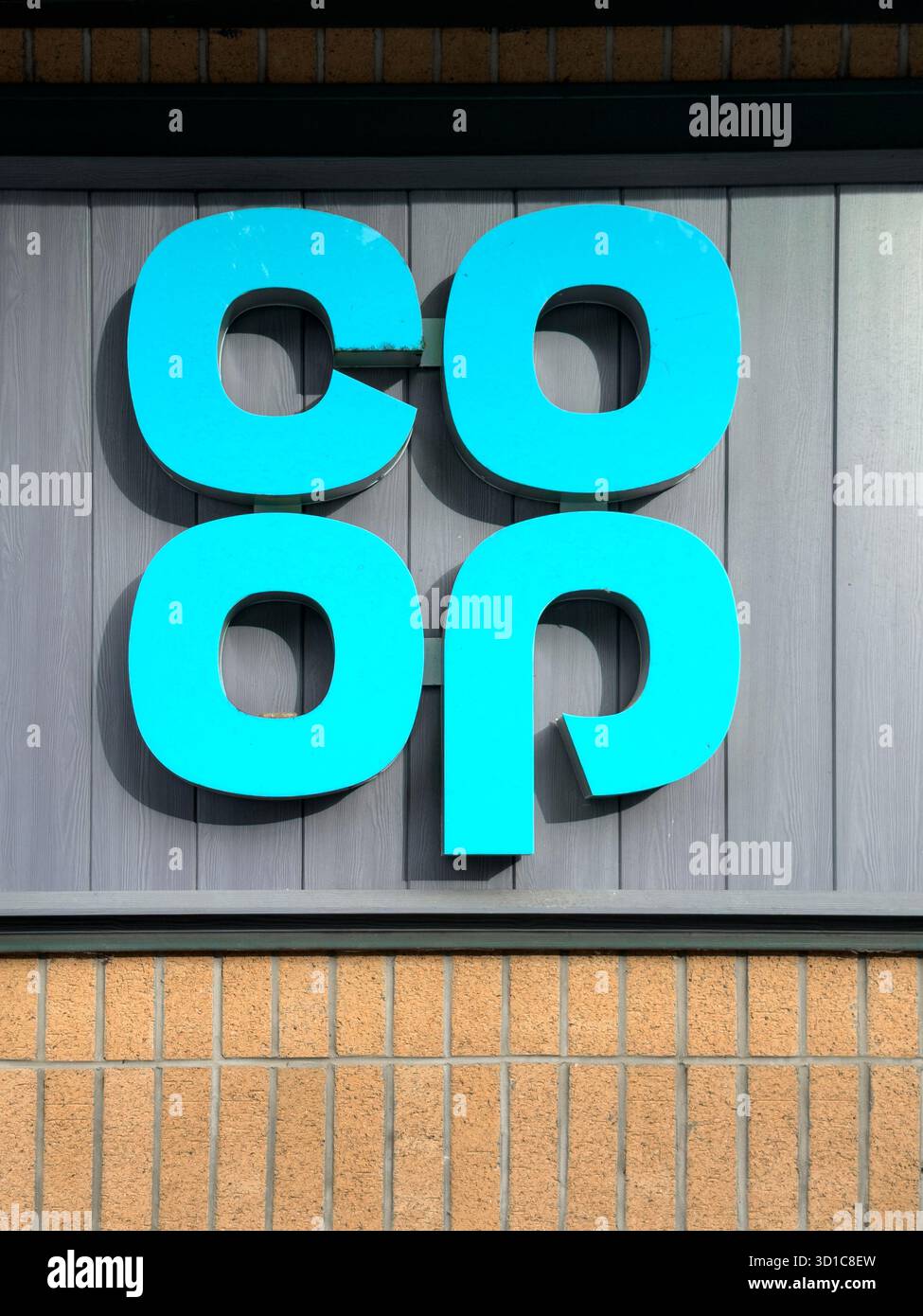 Close-up of the Co-op supermarket logo on the exterior facade of a store with modern panelling and brickwork in Prudhoe northumberland - Smartphone Captured Stock Image
