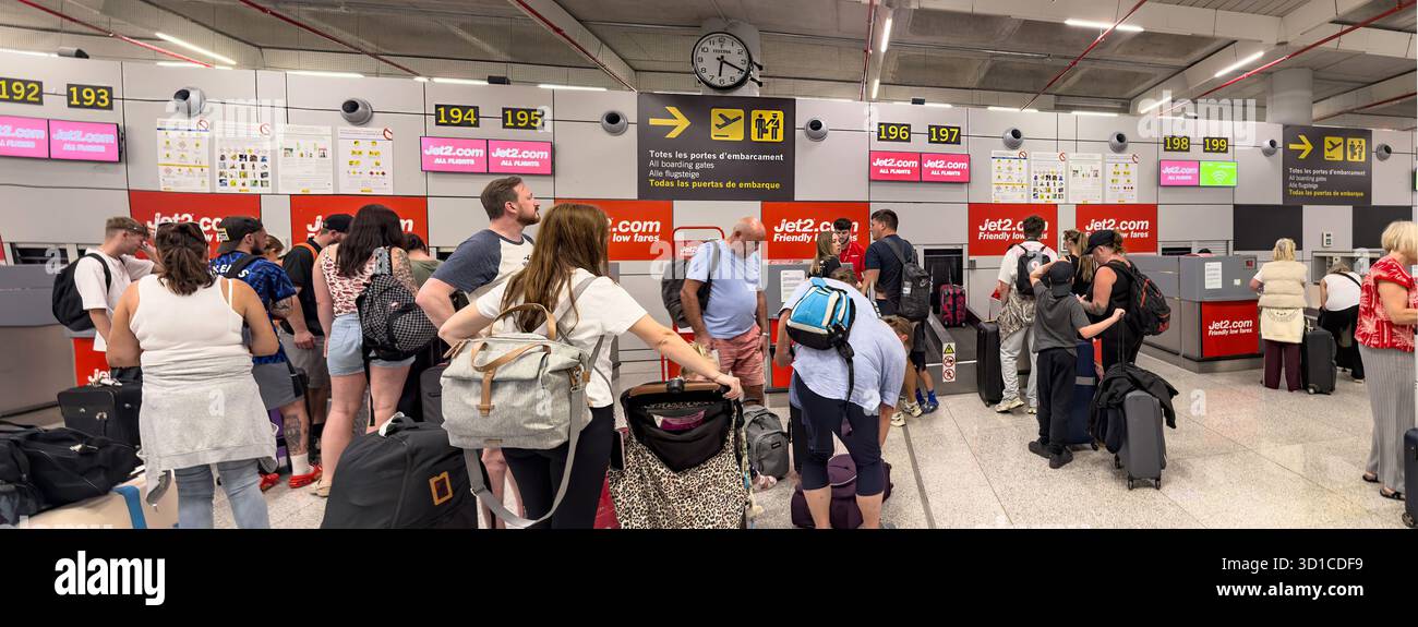 panorama Passengers waiting in line at an airport check-in counter for Jet2.com with luggage and travel documents in hand - Smartphone Captured Stock Image
