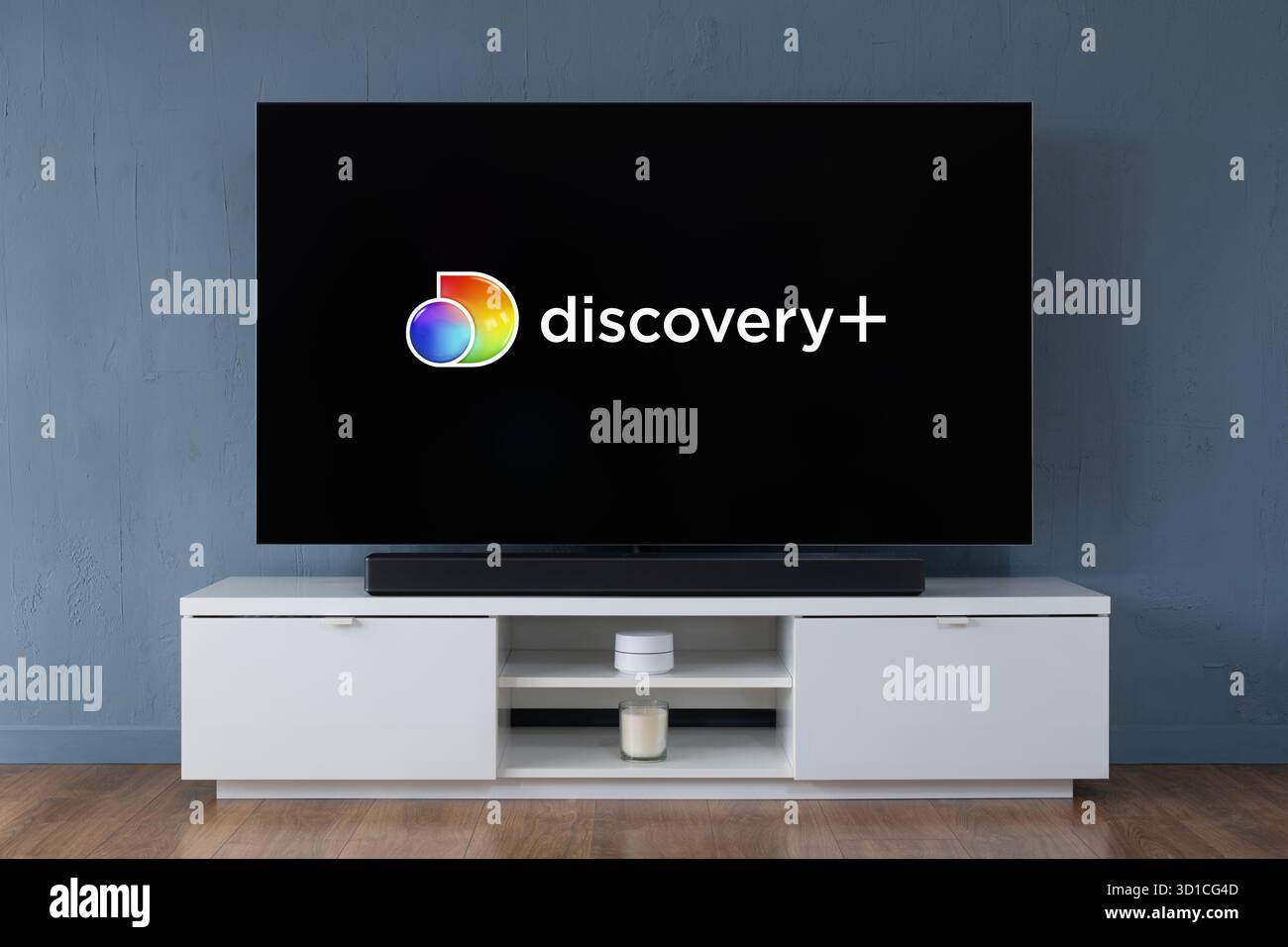 The Discovery+ streaming service logo is seen on a modern OLED widescreen TV. Stock Photo