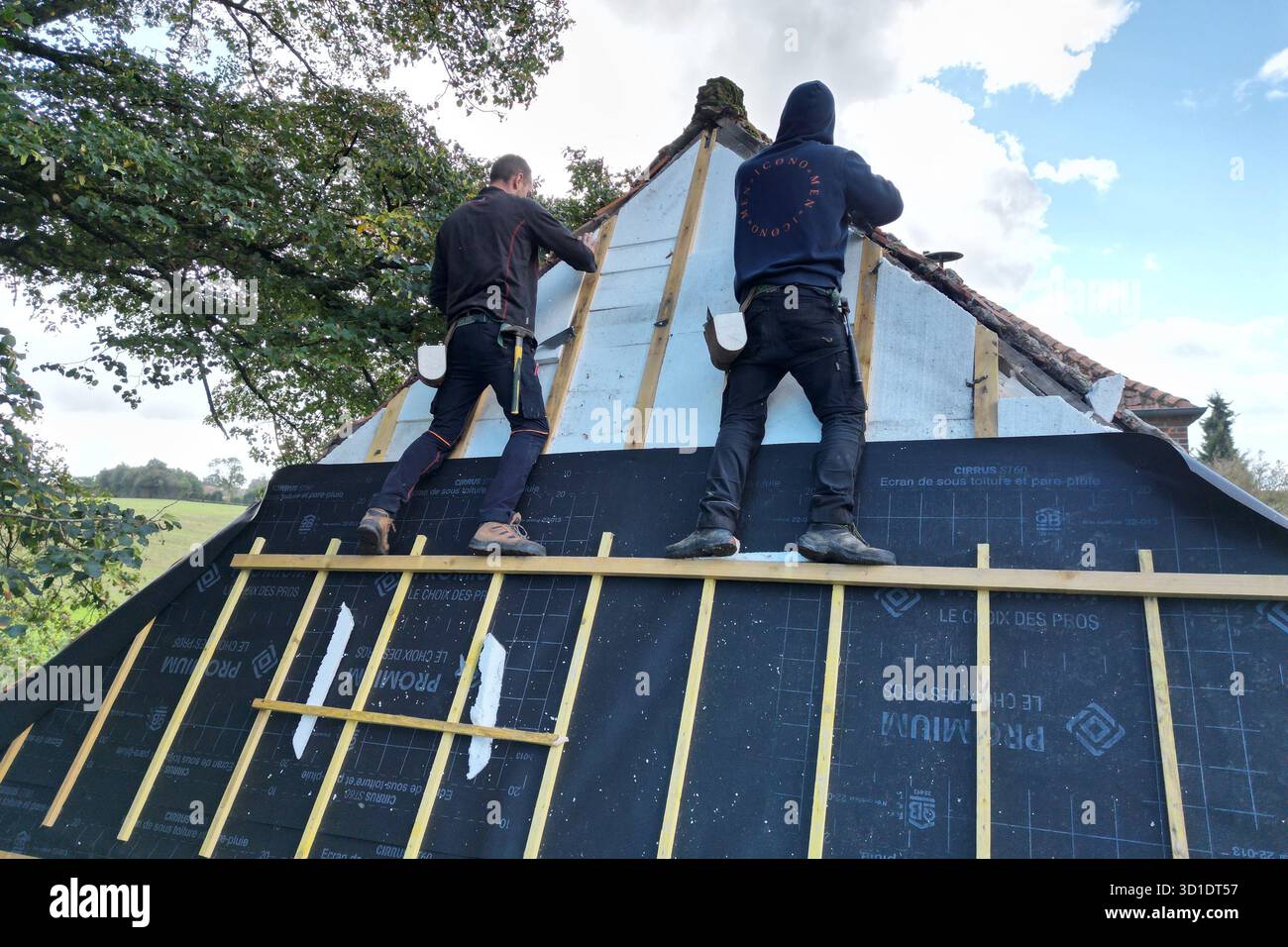 Pierremont, Hauts de France, France-October 1 2024: Two male roofers replace insulation to a Hip roof. Stock Photo