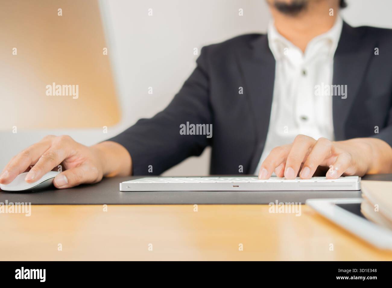 Businessman using computer with hands typing on a keyboard and holding computer mouse on workplace. Stock Photo
