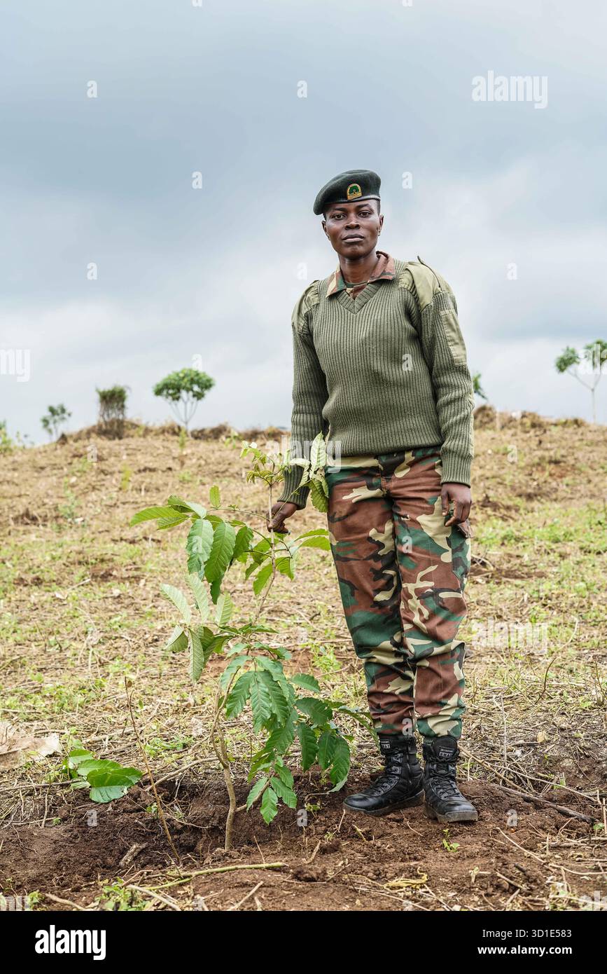 A forest ranger poses beside the tree she planted during the launch of ...