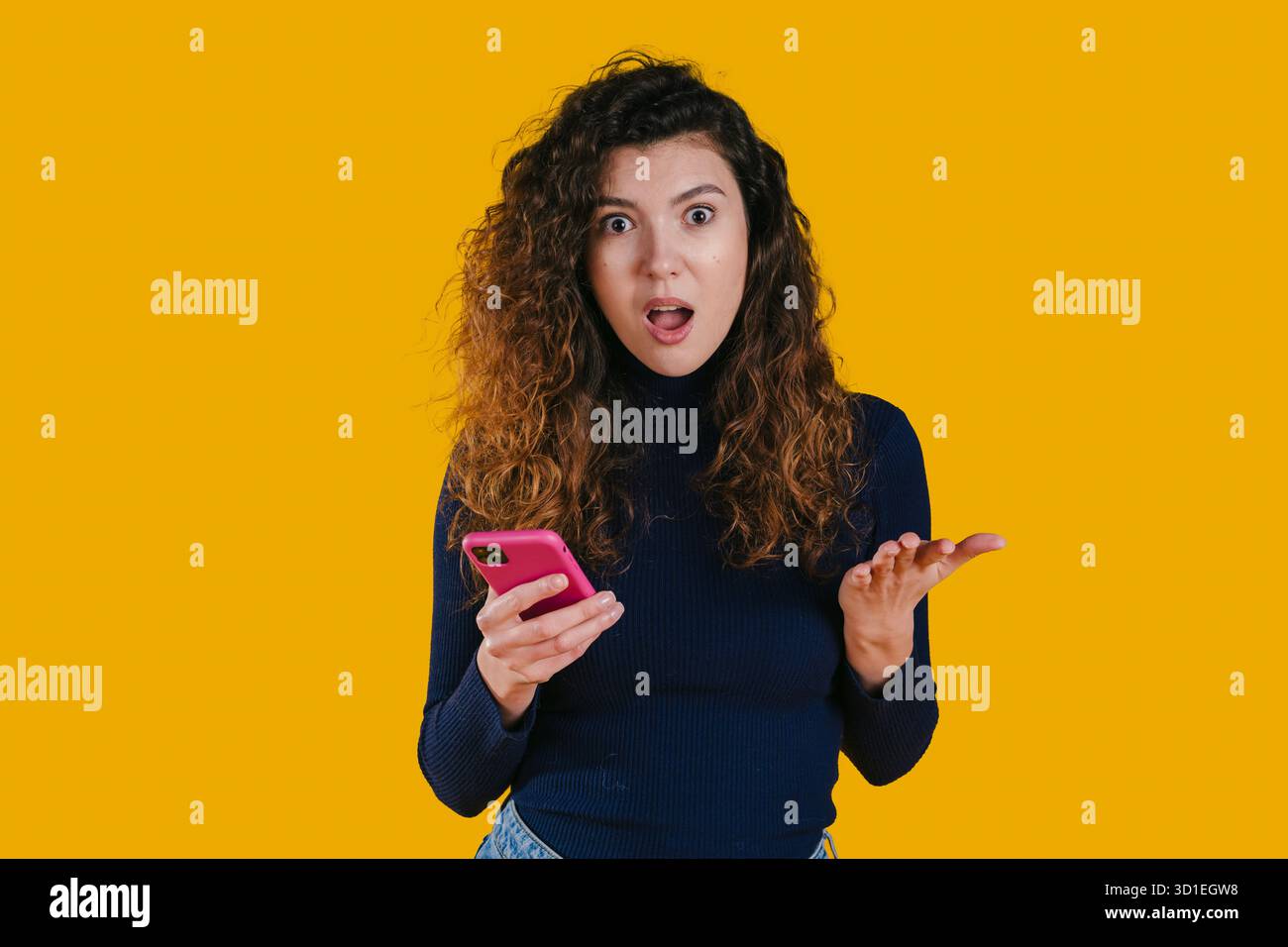 Brightly expressive woman shows surprise while using her mobile Stock Photo