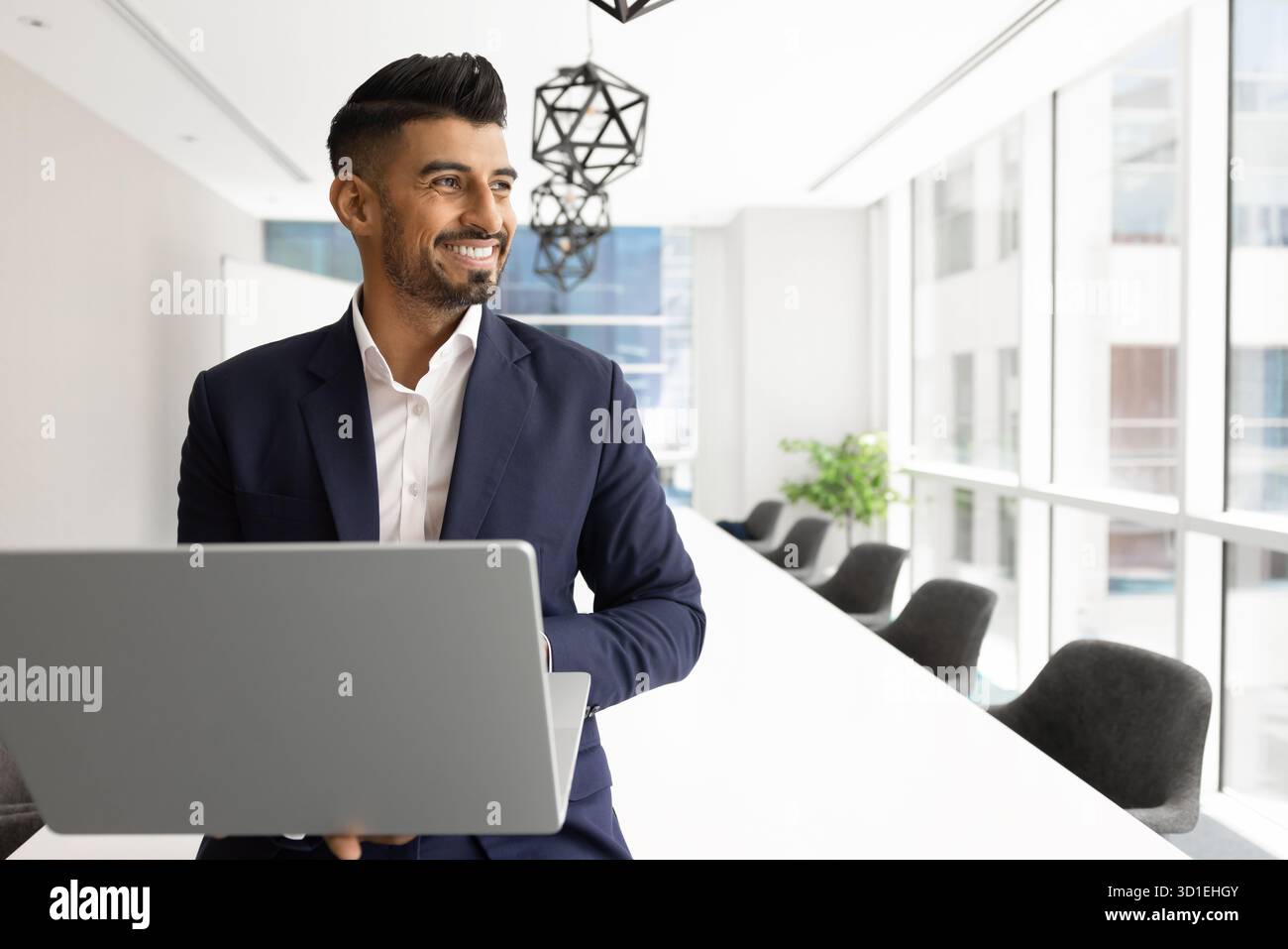 Happy young Indian business expert man using laptop Stock Photo