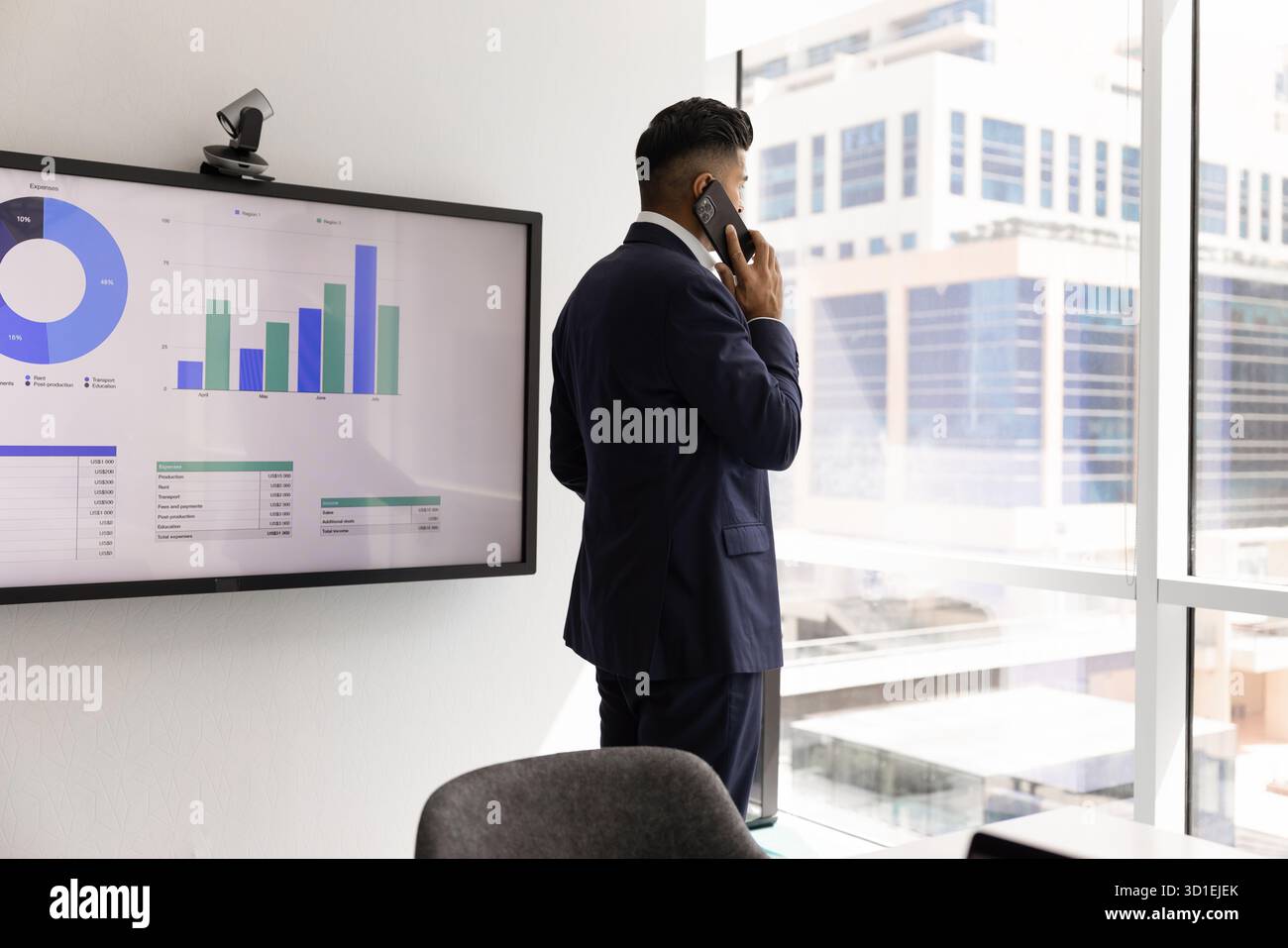 Thoughtful serious Indian businessman talking on mobile phone Stock Photo
