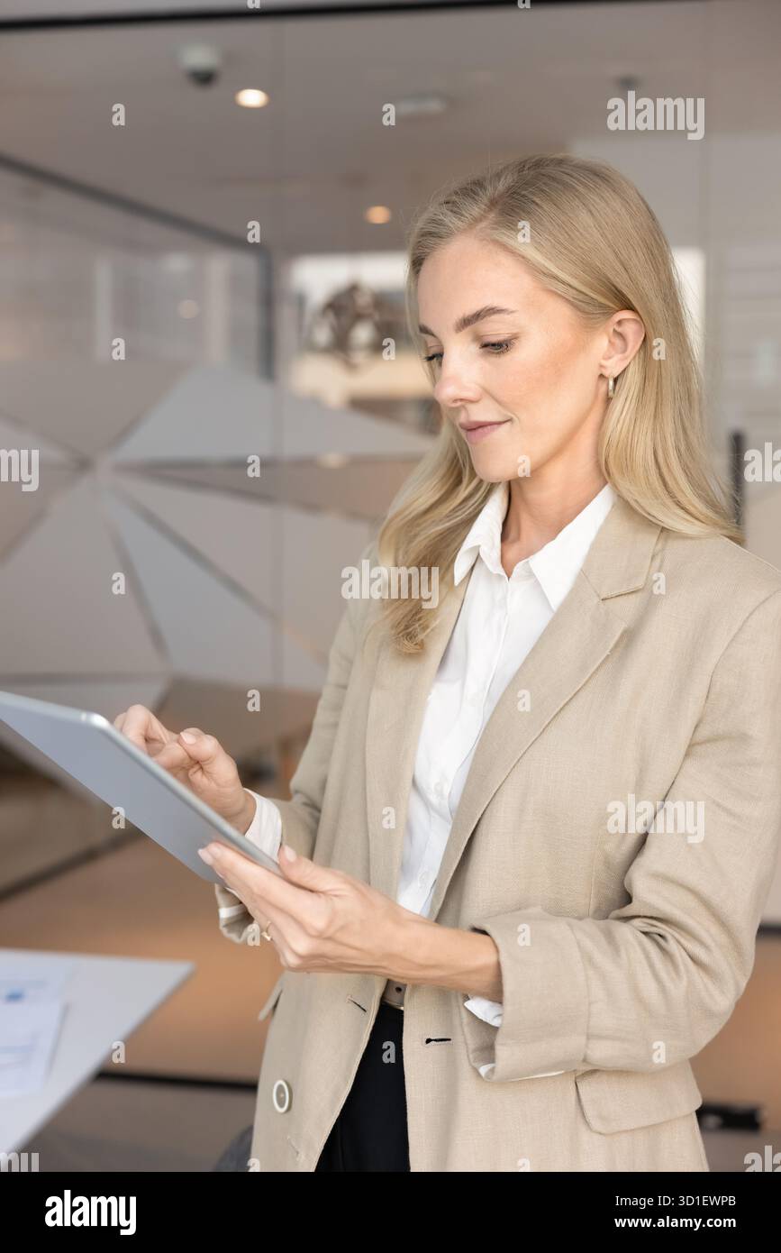 Focused busy young executive woman typing on digital tablet pc Stock Photo