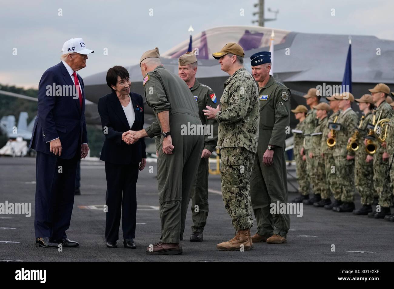 Japanese Prime Minister Sanae Takaichi, with President Donald Trump, is greeted by U.S. navy personnel aboard the USS George Washington, an aircraft carrier docked at a U.S. naval base, in Yokosuka, south of Tokyo, Tuesday, Oct. 28, 2025. (AP Photo/Mark Schiefelbein) Stock Photo