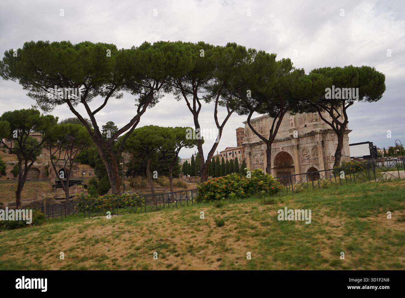 An ancient Roman triumphal arch seen behind the iconic silhouettes of ...