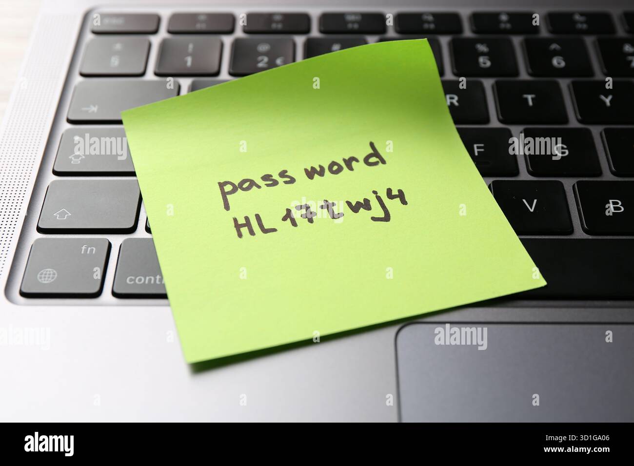 Sticky note with password on laptop, closeup Stock Photo