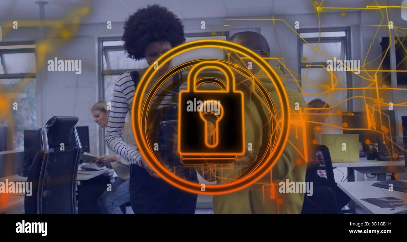 Four cybersecurity professionals analyzing holographic padlock overlay in open-plan office Stock Photo