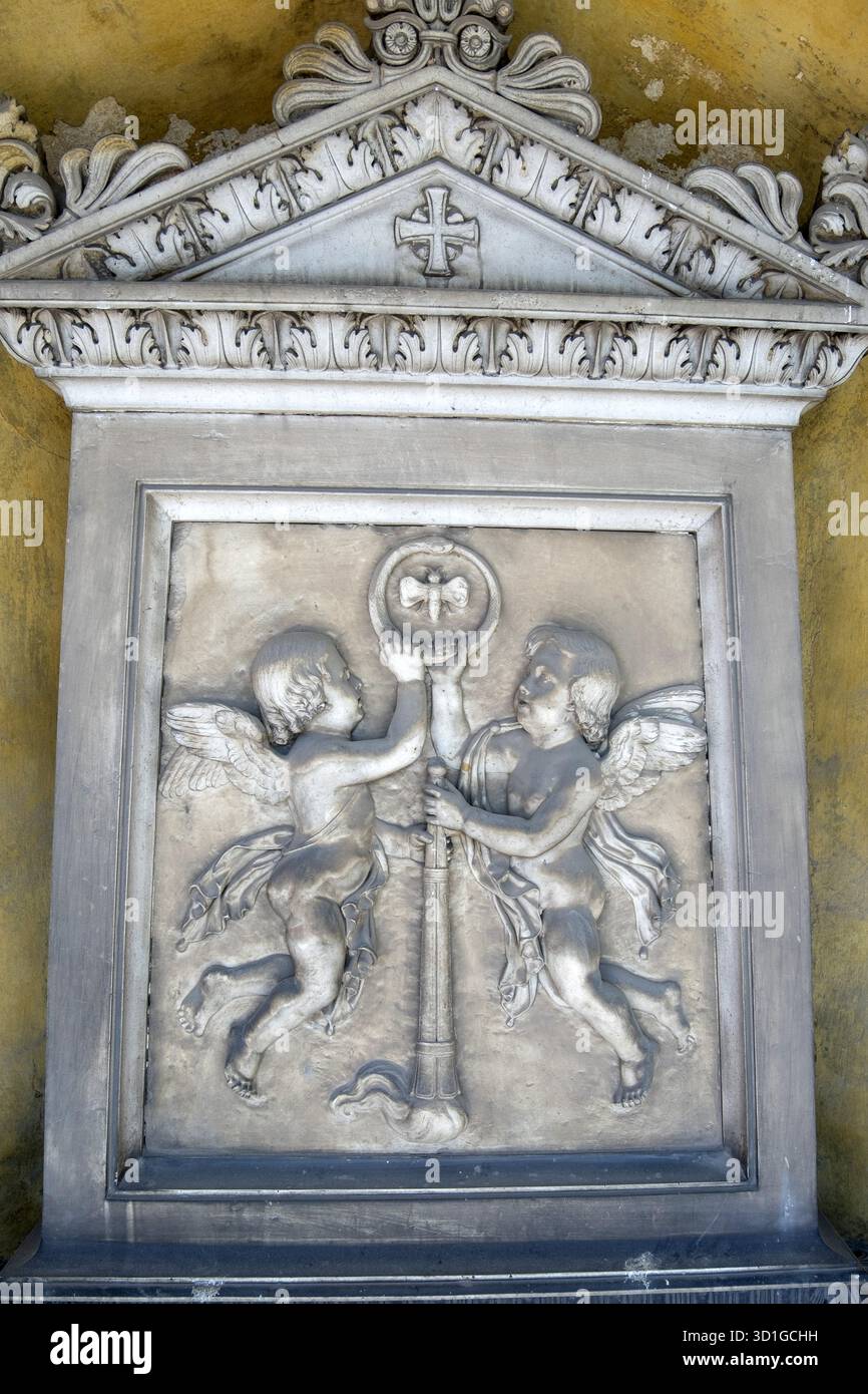 Marble funerary relief depicting two winged cherubs holding a symbol of ...