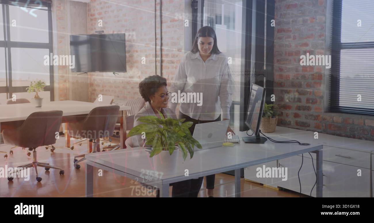 Two coworkers wearing business attire reviewing laptop content in open ...